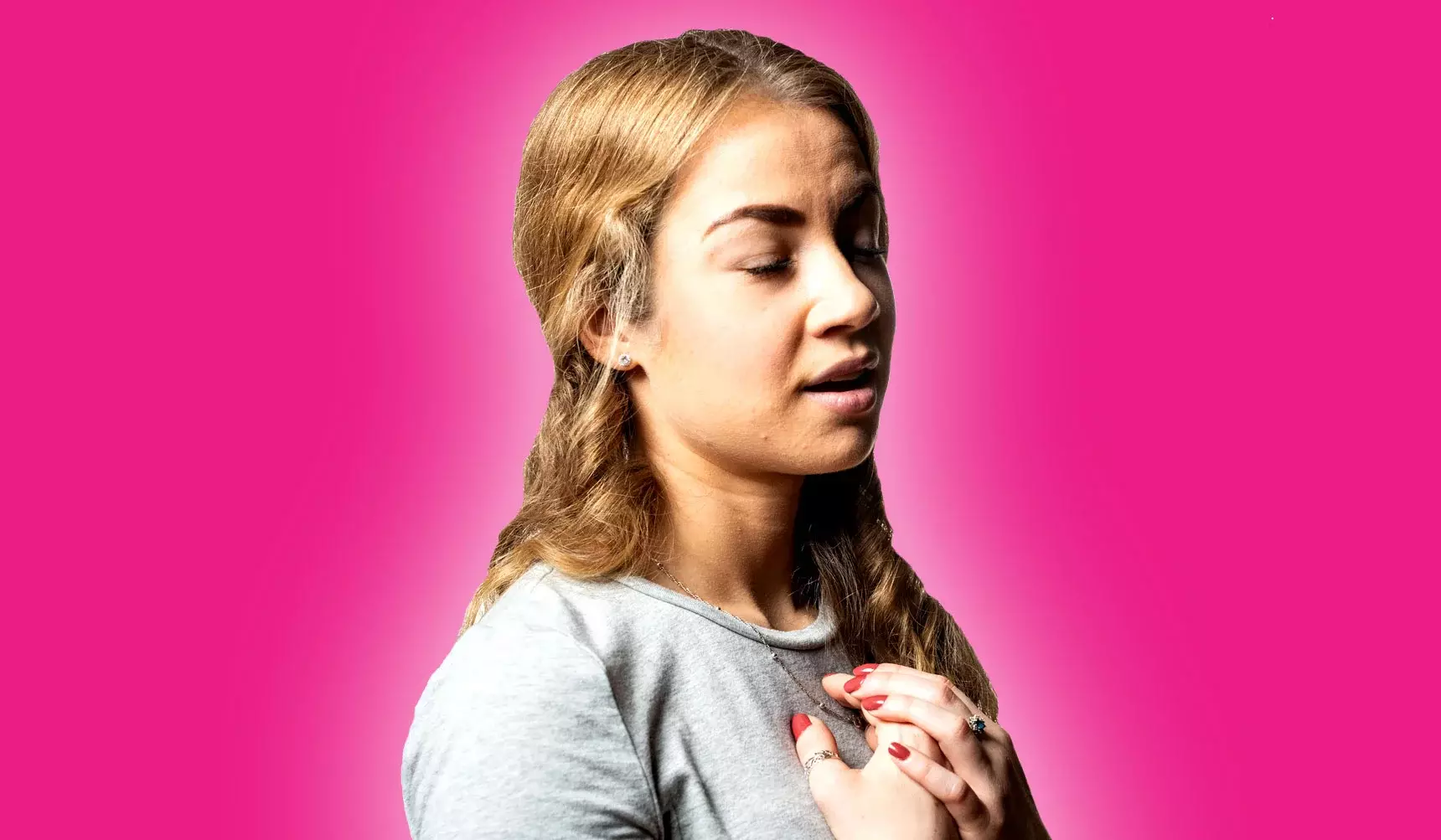 Girl in acting pose with hands clutched to chest