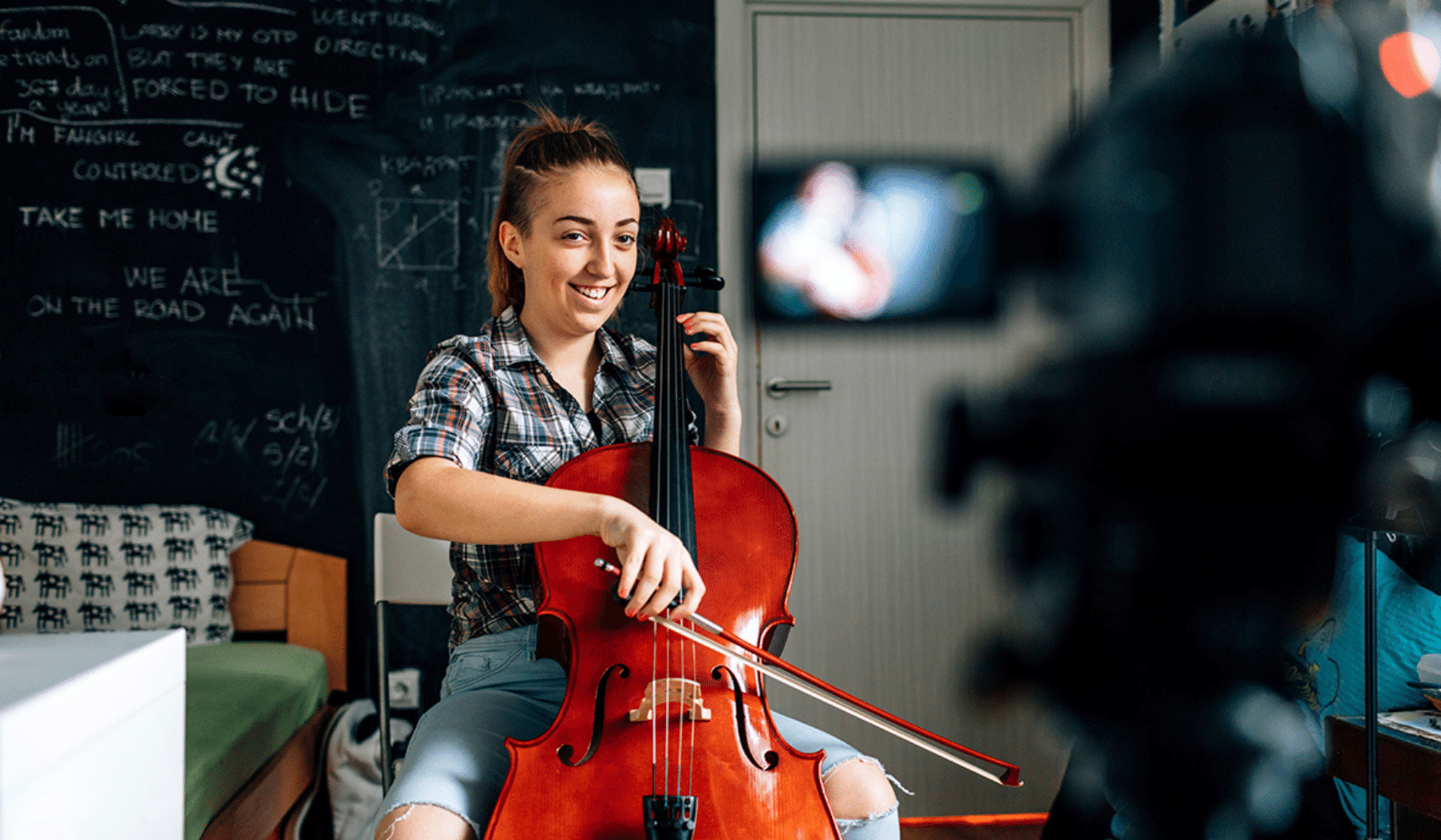 Girl with cello being recorded on a camera